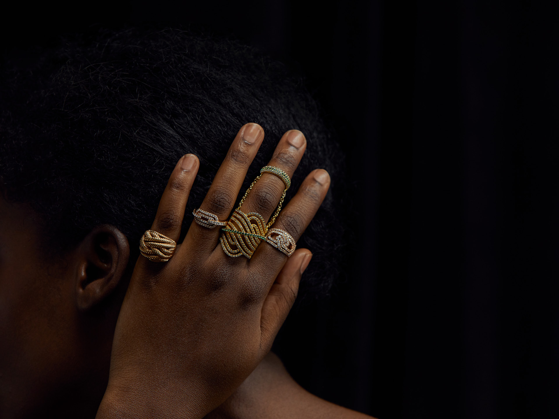 Detailed crop of a black woman and her hand wearing golden jewellery from William and Son