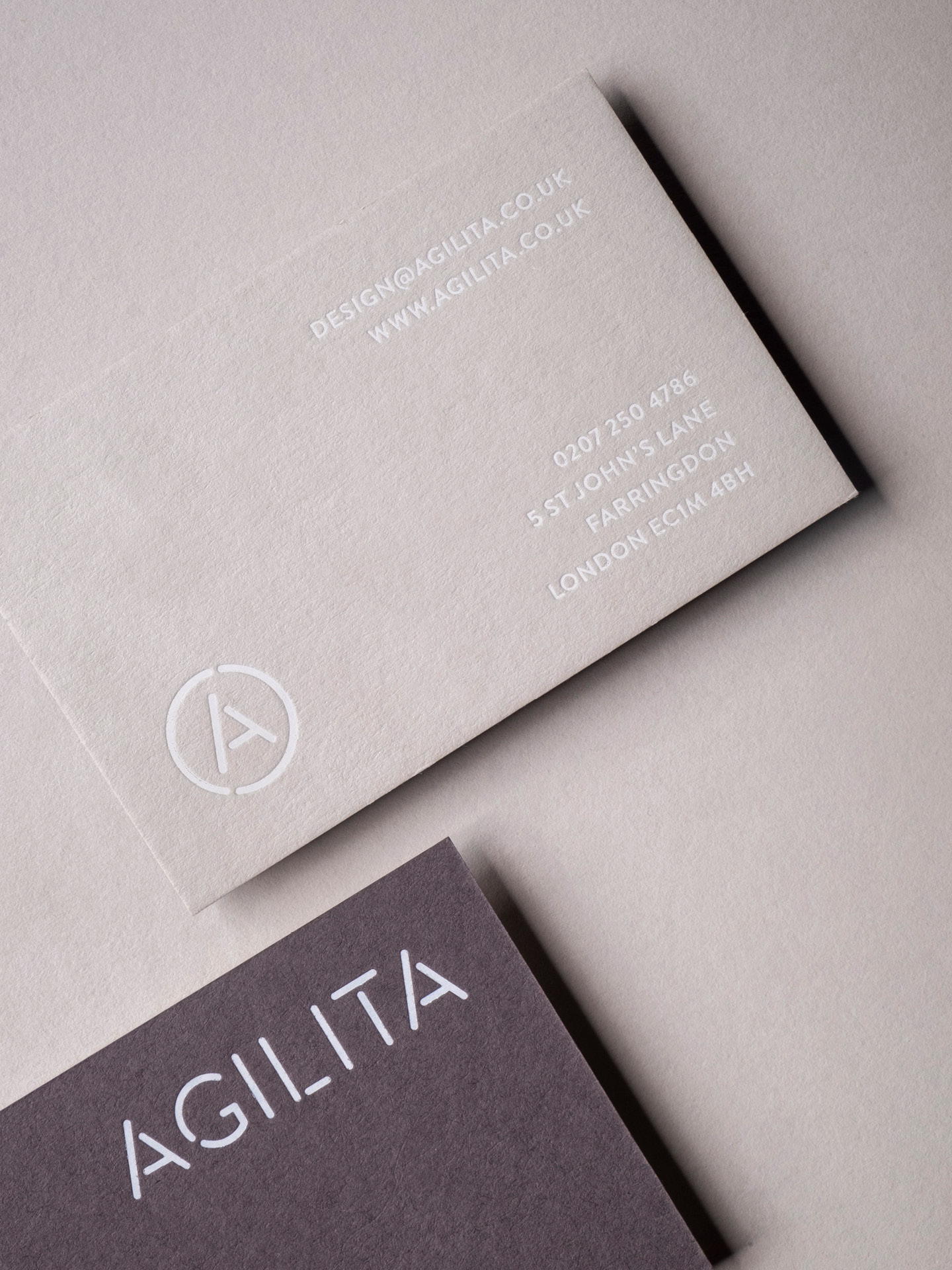 Close up image of the business cards printed with duplexed pale grey and dark grey with white foil on both sides
