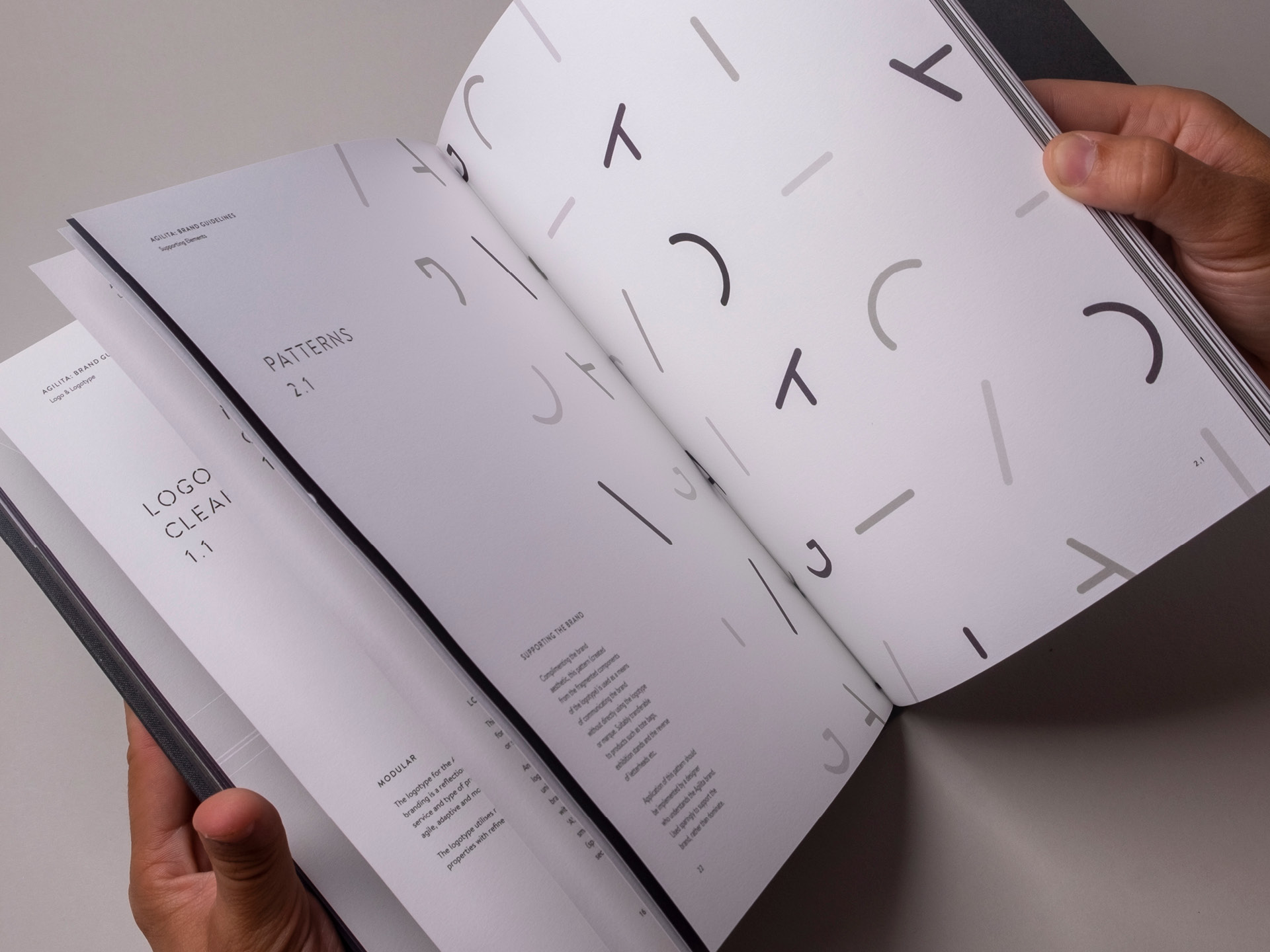 Flicking through the pages of the brand guidelines book detailing the supporting brand pattern made from a deconstructed logotype