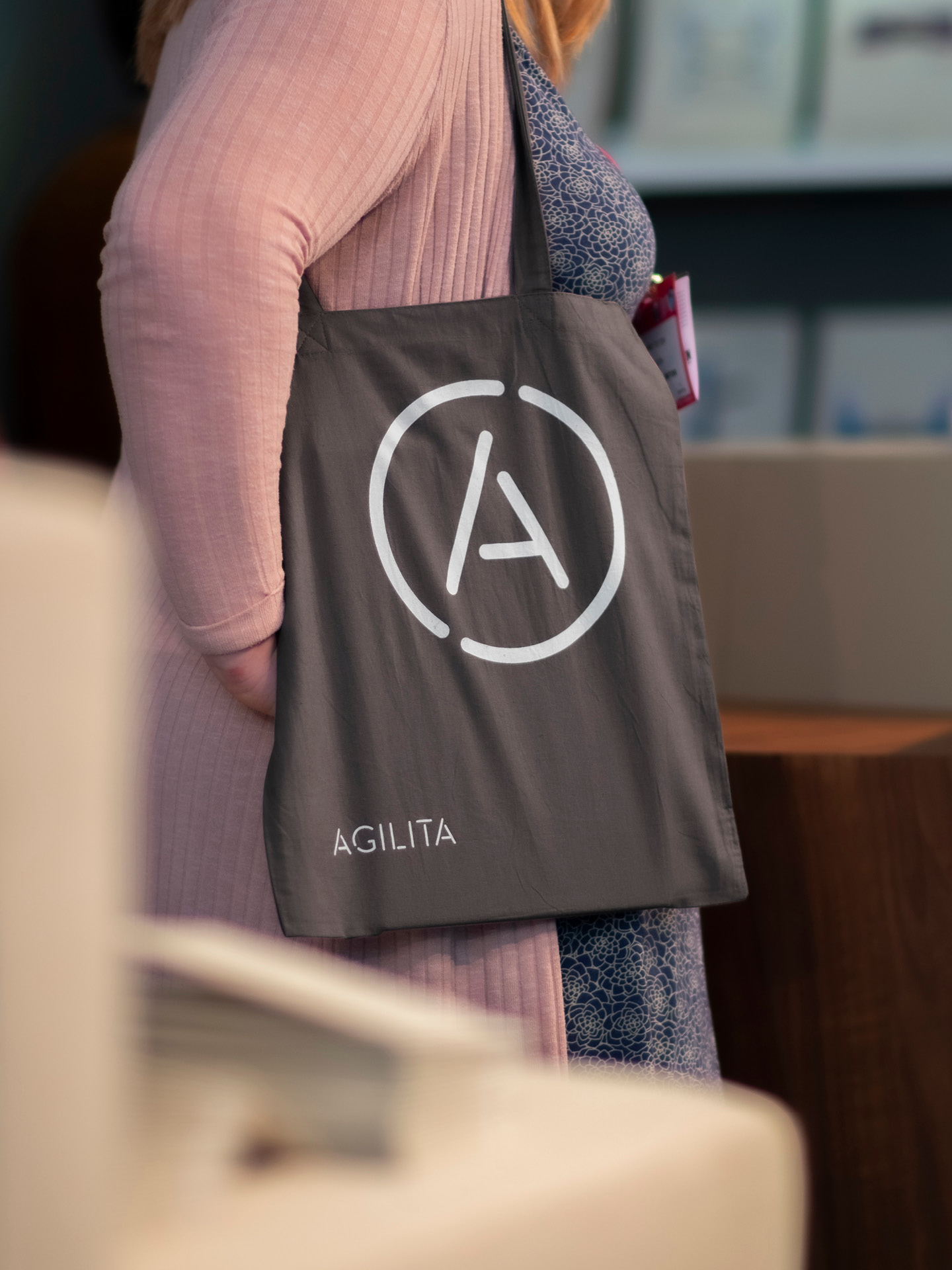 A photo of a woman carrying the Agilita branded tote bag at the exhibition