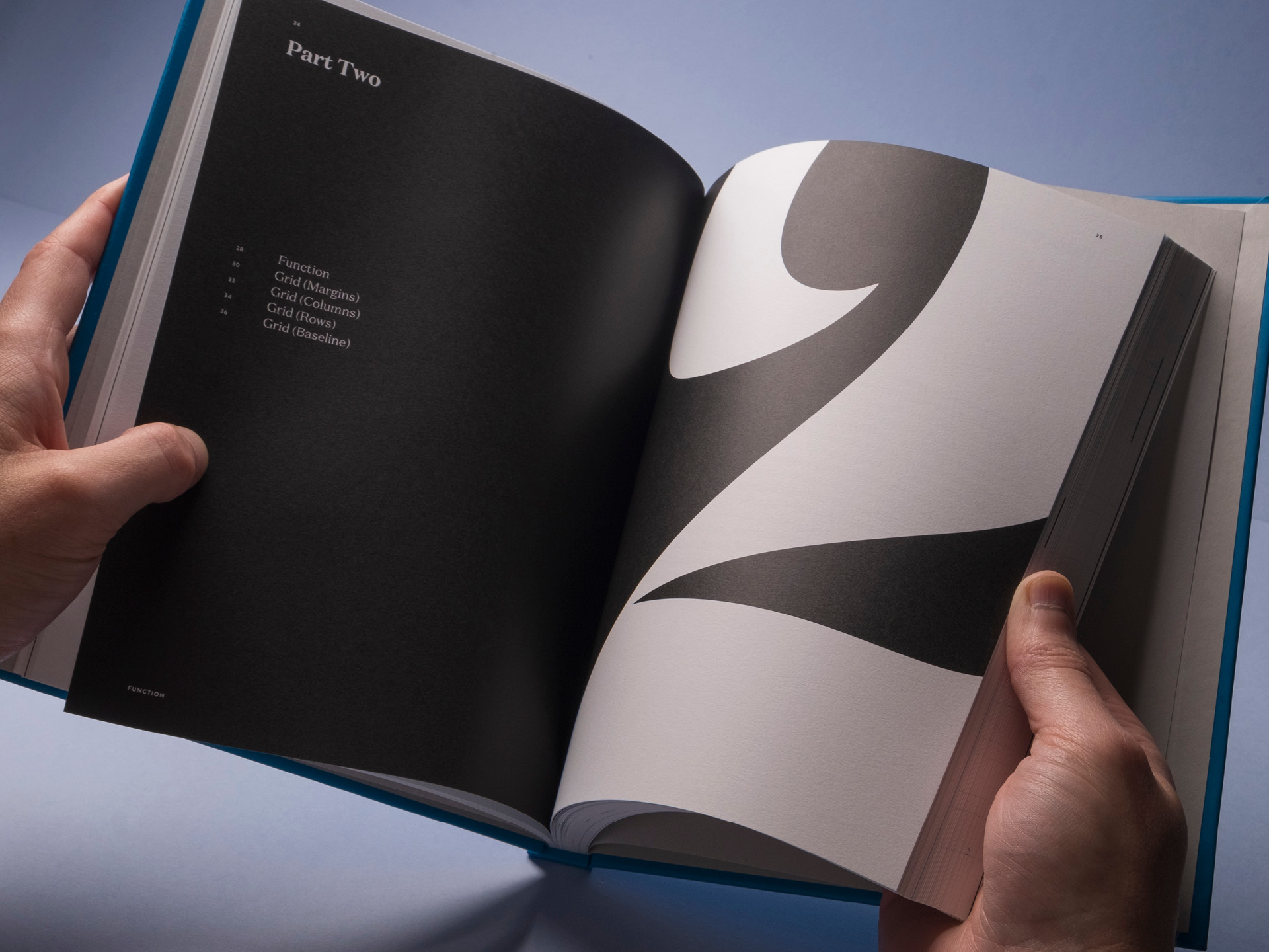 A spread from Chapter two of the Be Specific book held open with a large typographic numeral filling the right hand page
