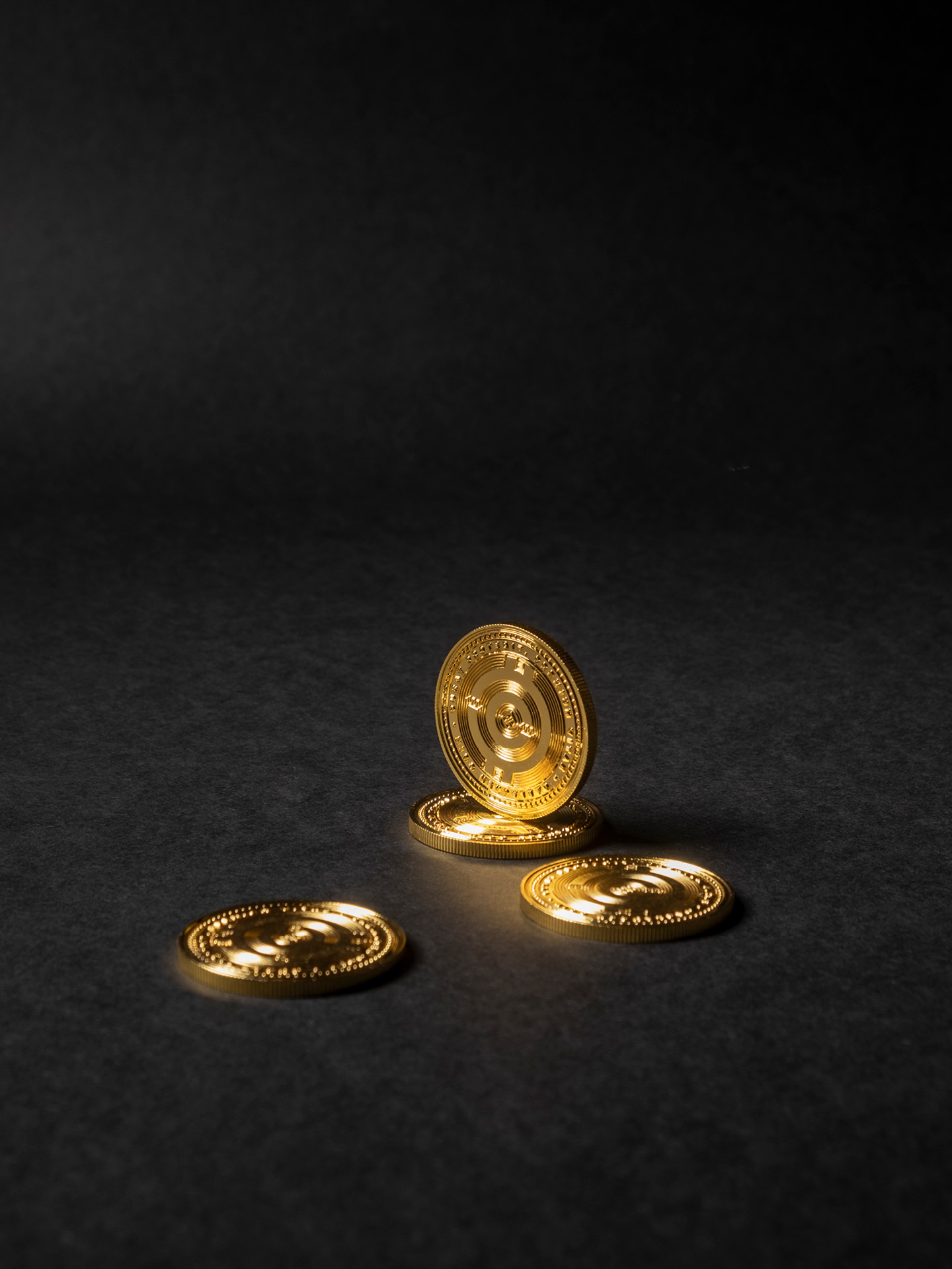 Four golden coins made for the digital currency promoted by the brand