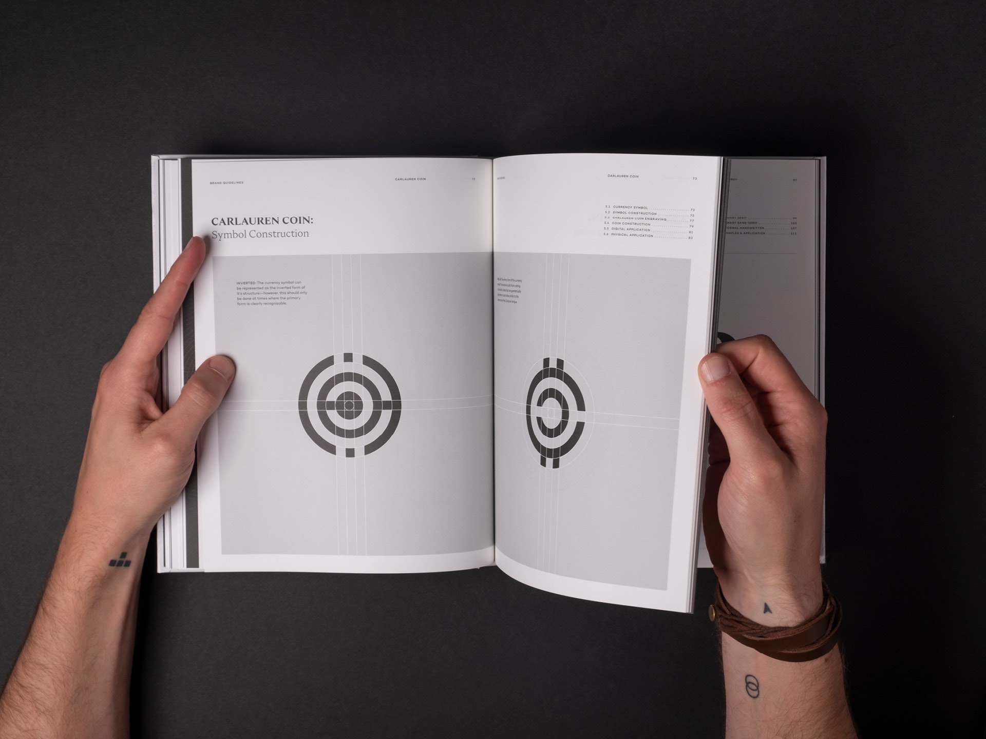 A printed spread from the Carlauren guidelines showcasing the currency icon featured on the coin