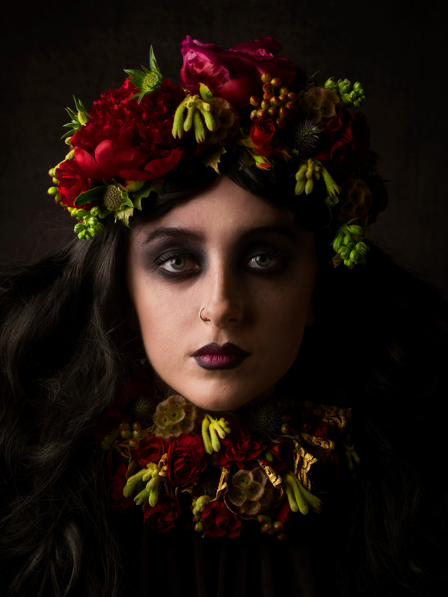 Portrait photography of model Bethan Perkins with coral crown and neck ruffle with dark makeup on her eyes and lips, with nose piercing by Ben Budden