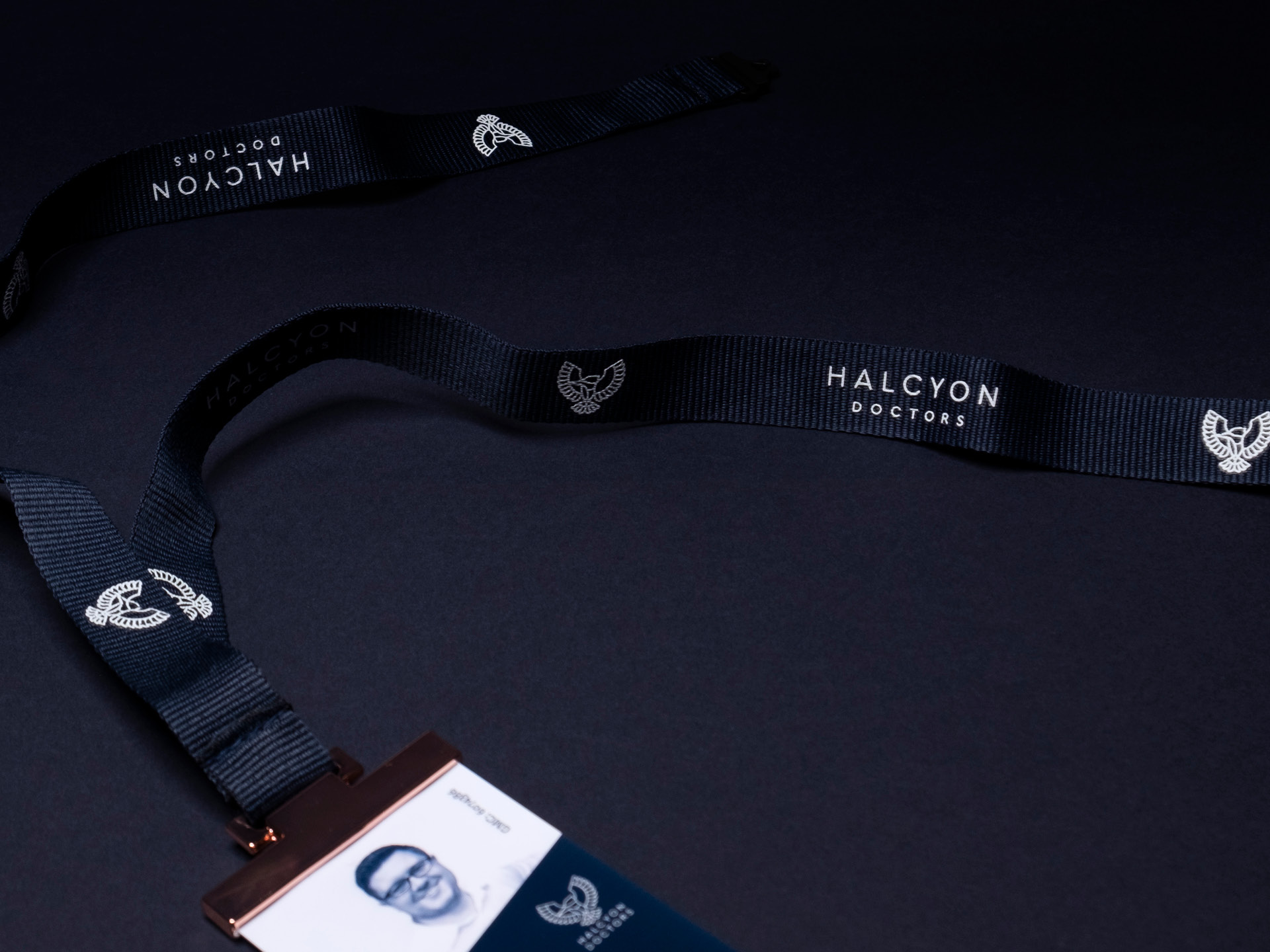 A halcyon doctors branded lanyard and identification badge with a metallic copper clip